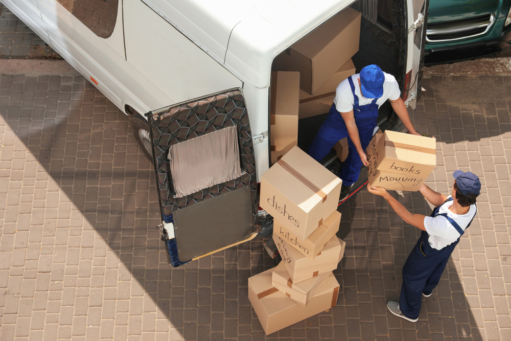 Male Movers Unloading Boxes From Van